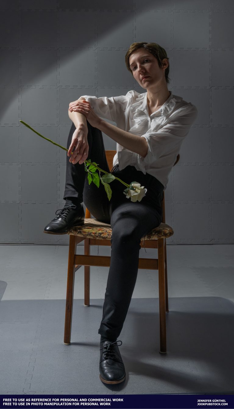 a person sitting in a chair holding a rose
