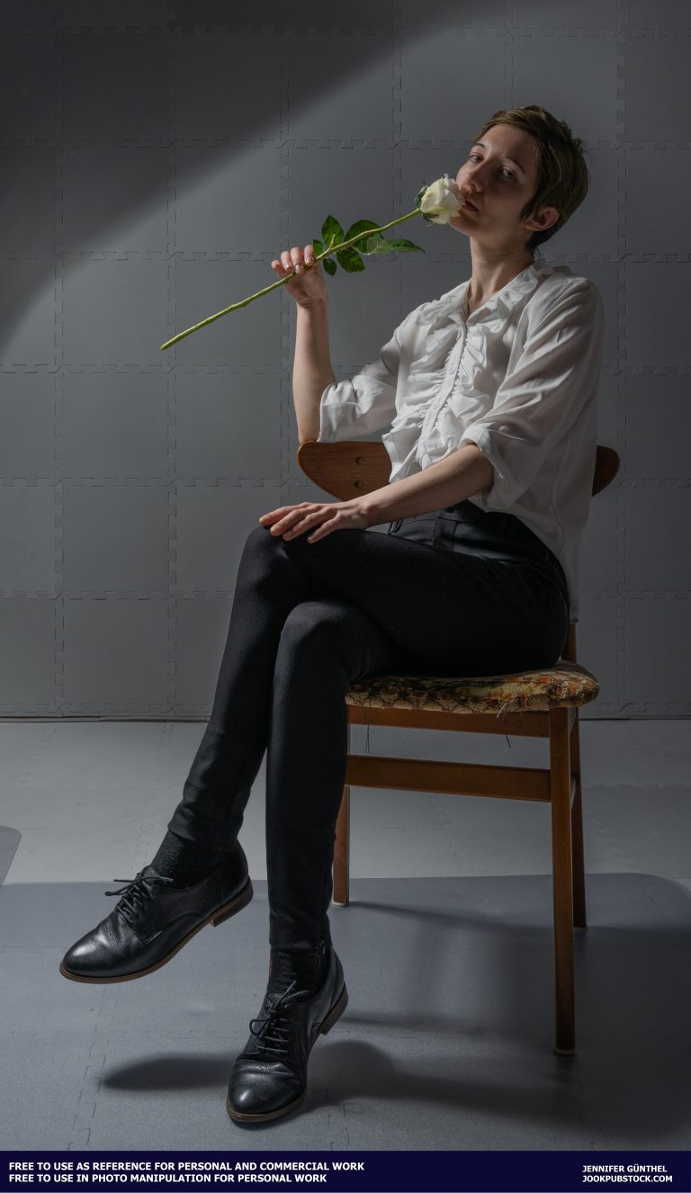 a person sitting in a chair holding a rose