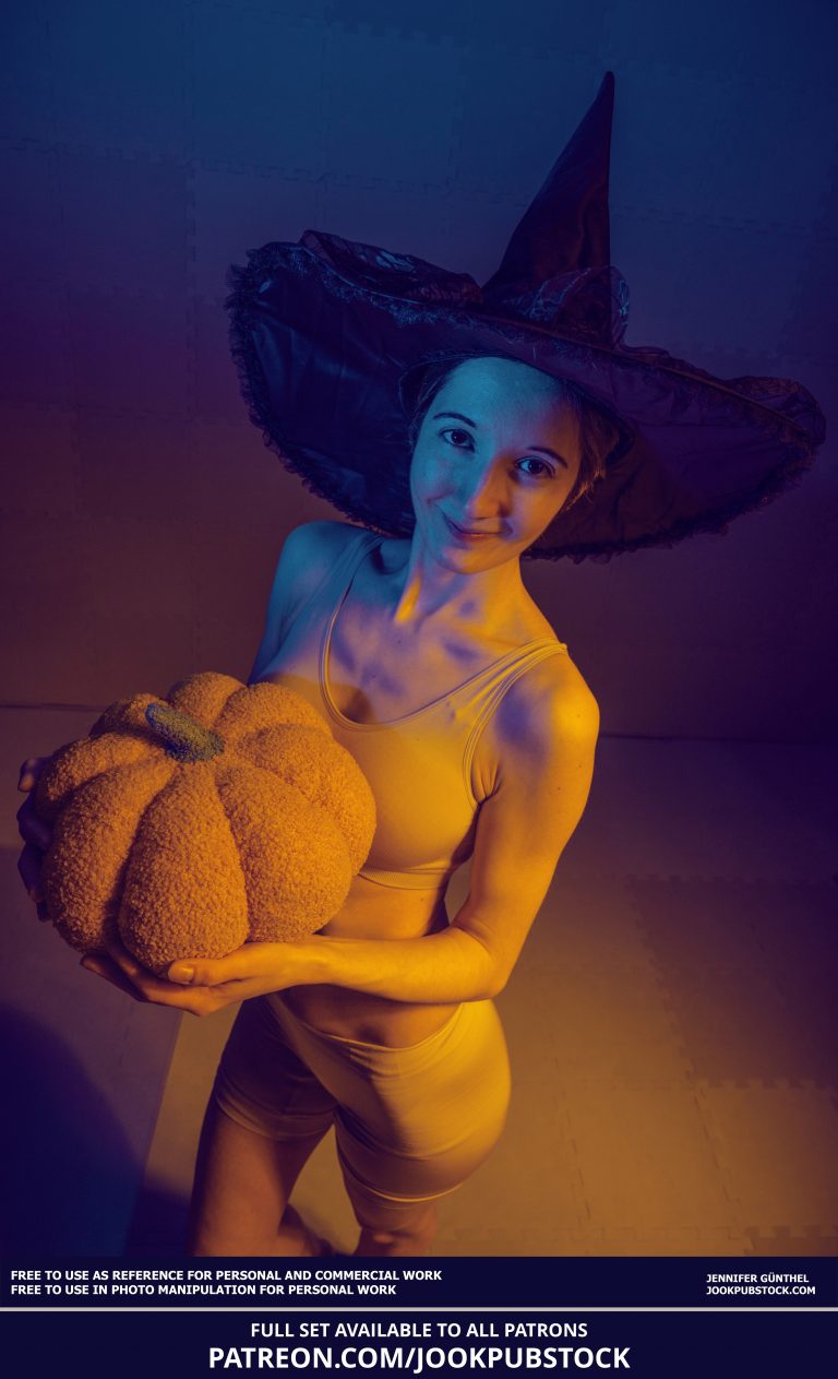 a person wearing a witch hat and holding a pumpkin