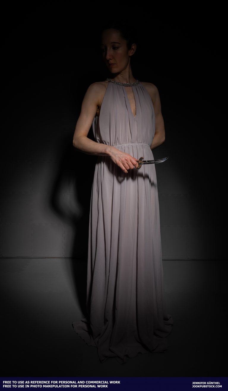 a person in a long dress holding a dagger