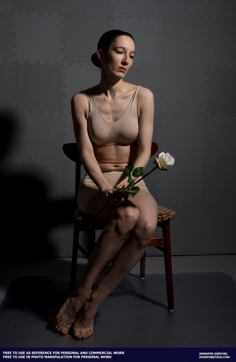 a person sitting on a chair holding a flower