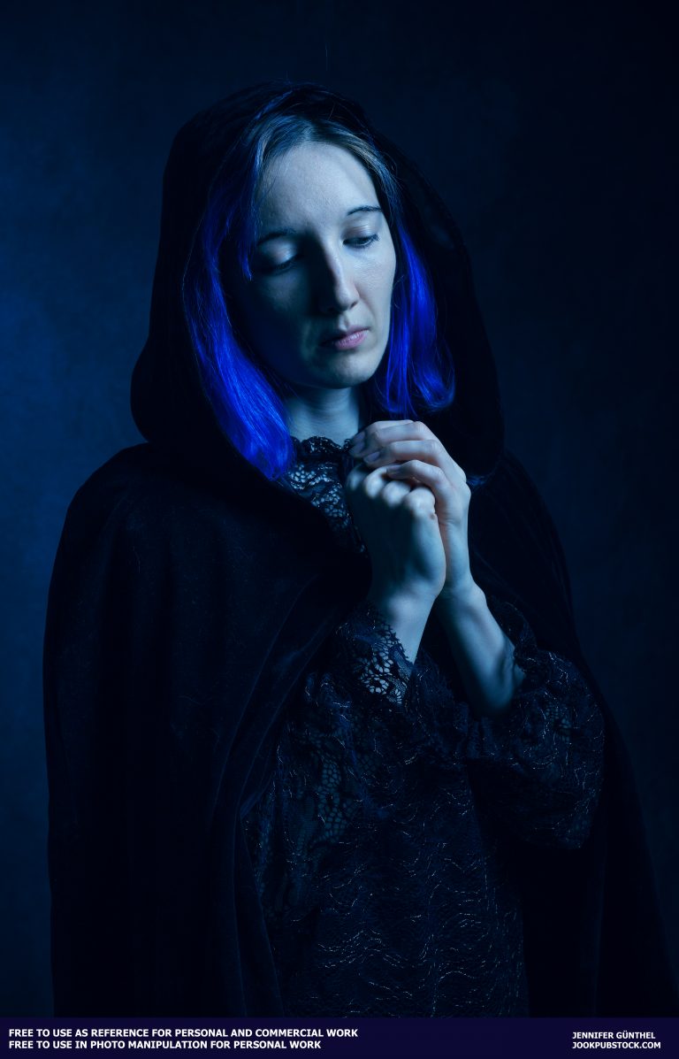 a person with blue hair wearing a black hood