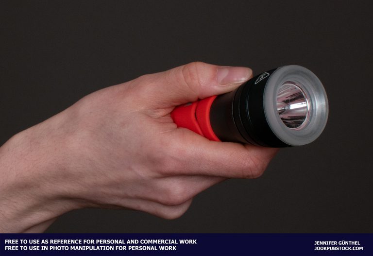 a hand holding a flashlight