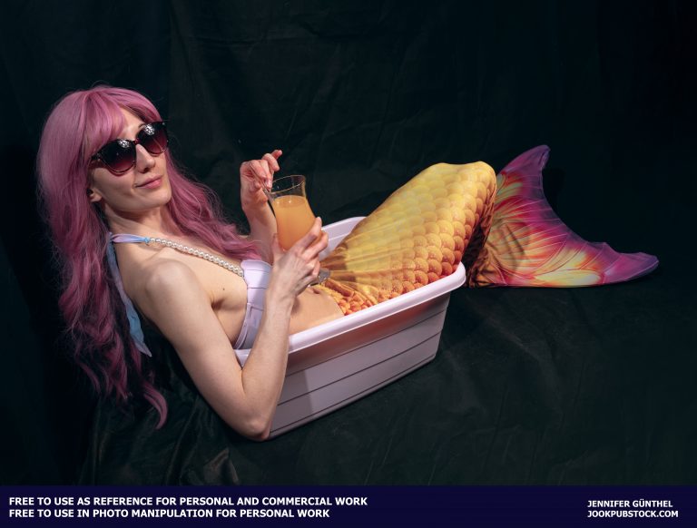 a person in a mermaid costume wearing sunglasses and holding a cocktail glass
