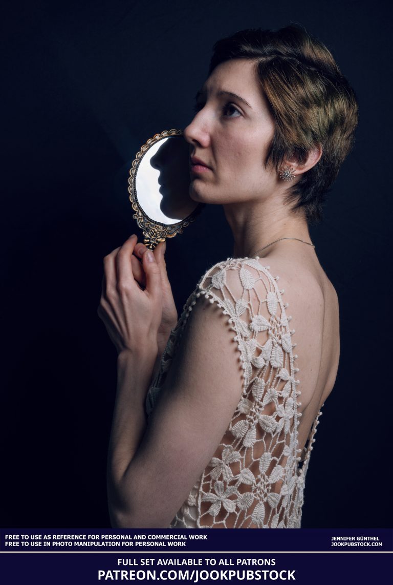 a person in a white dress holding a mirror