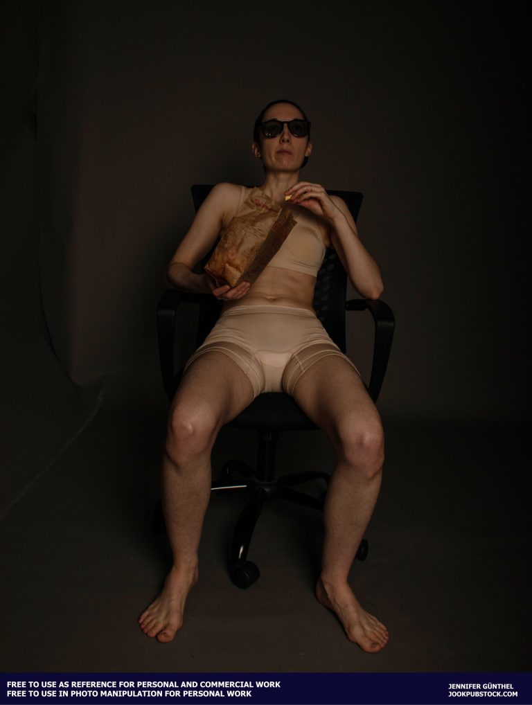 a person sitting in a chair, wearing sunglasses and eating popcorn