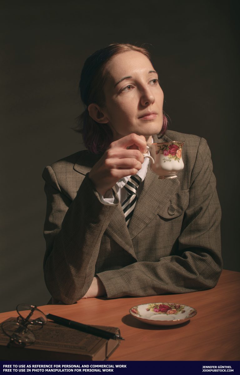 a person wearing a suite and holding a tea cup