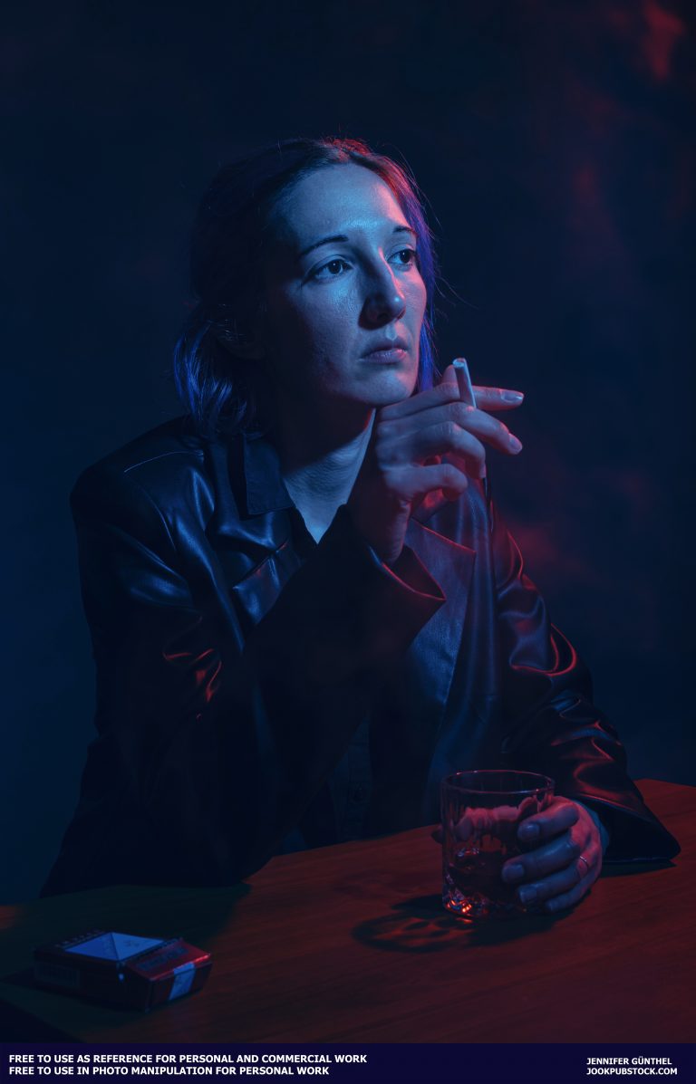 a person holding a cigarette and a glass